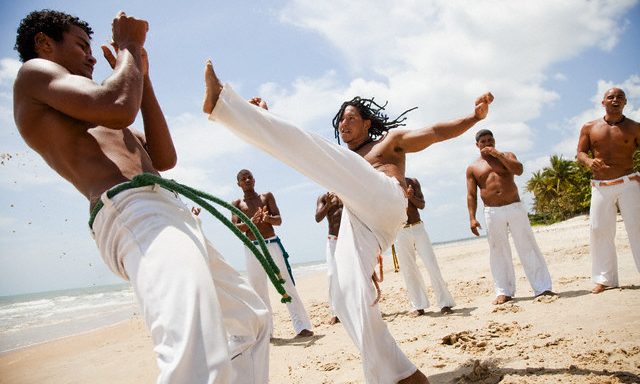 Trancoso, Brazil --- Young Men Practicing Capoeira --- Image by © Blue Images/Corbis